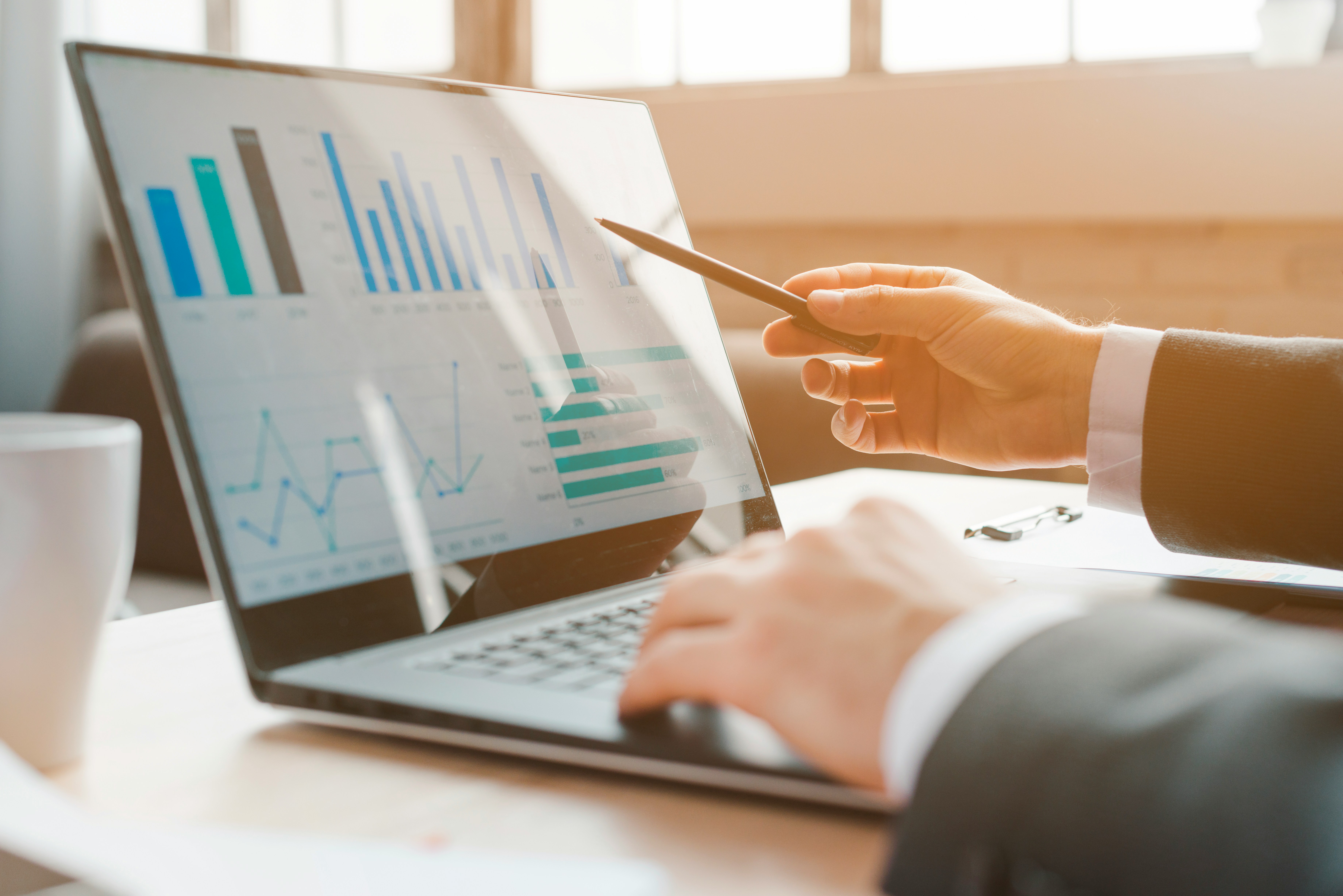 Consultant reviewing business performance charts on a laptop